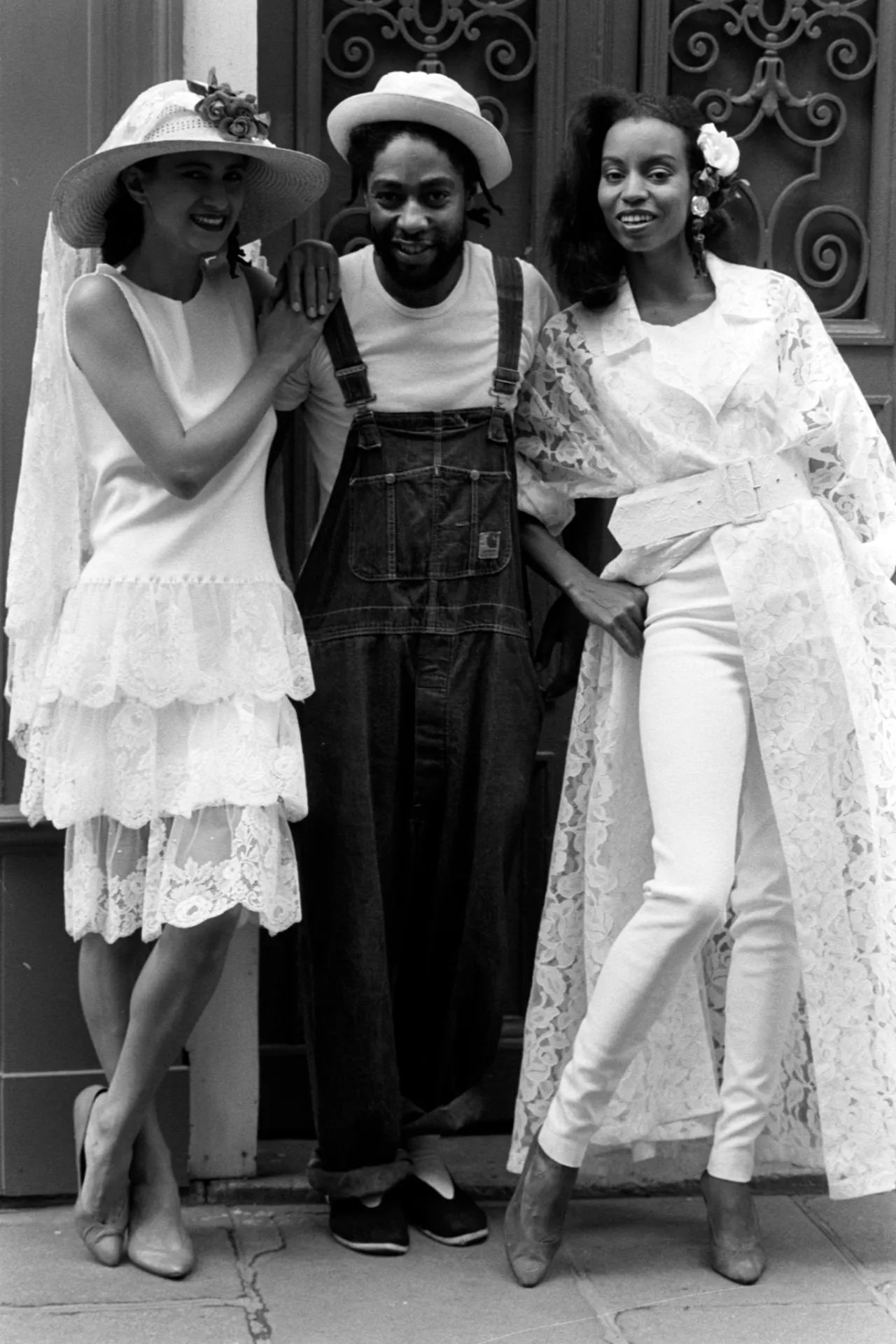 Patrick Kelly poses for a portrait with models in looks from his spring rtw 1986 advance on location in Paris on Oct. 1, 1985.