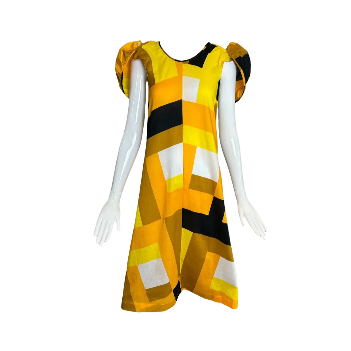 A sleeveless A-line dress displayed on a white mannequin, featuring a bold geometric pattern of yellow, black, and white blocks with puffed cap sleeves, set against a white background with black borders.